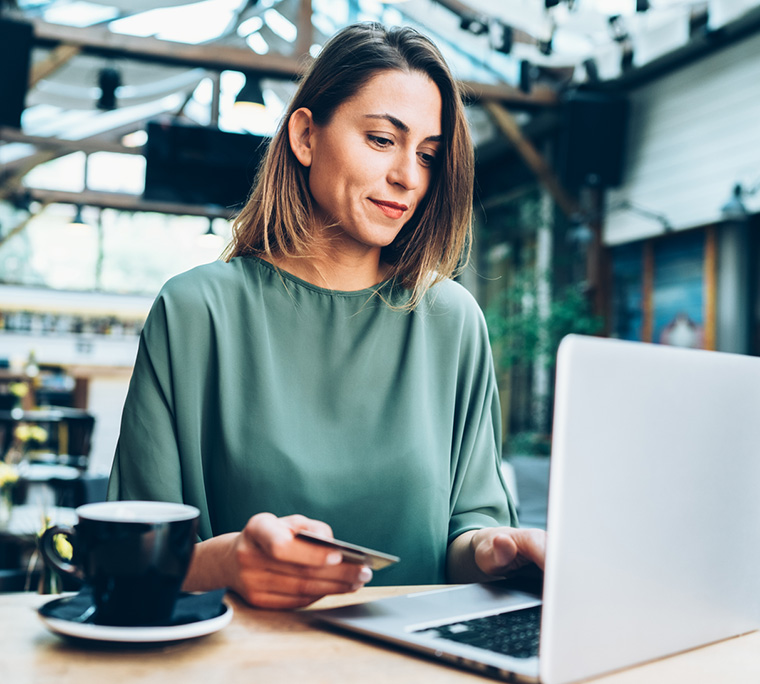 woman on computer, person on computer, woman with credit card, person paying bill