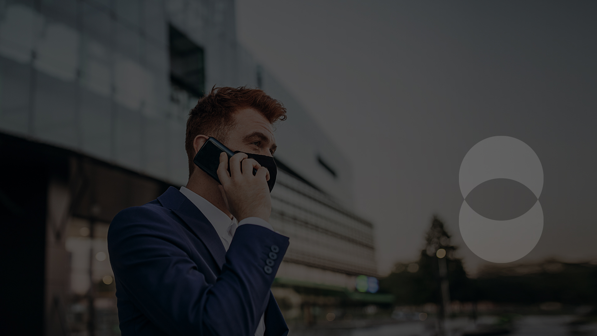 Man wearing mask talking on mobile outside of building