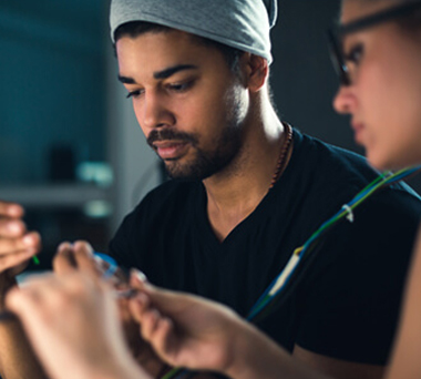Two people fixing computer parts