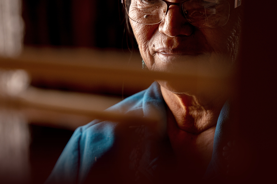 Indigenous elder working on loom