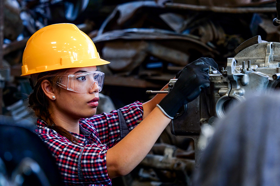 Indigenous woman in hard hat working on heavy machinery