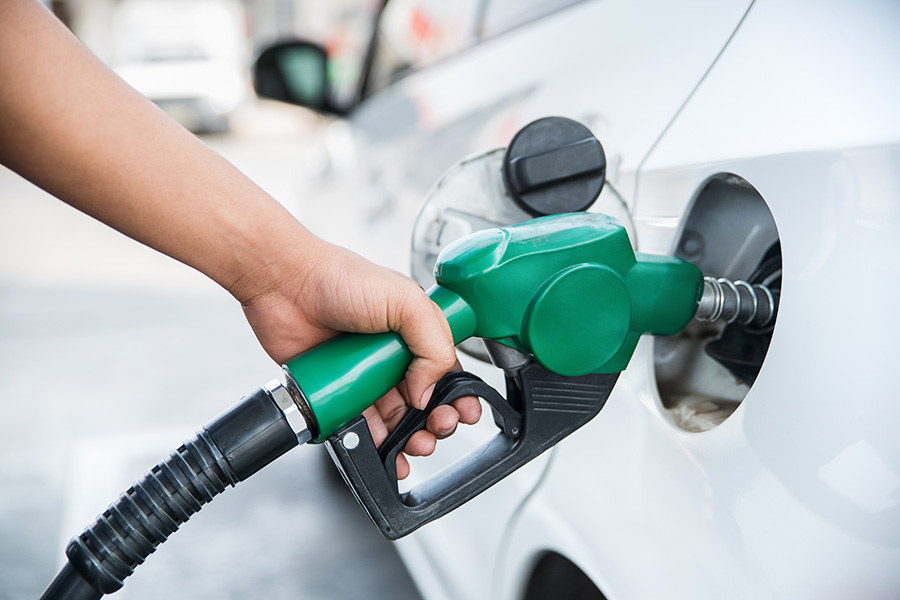 Hand holding pump to fill car gas tank