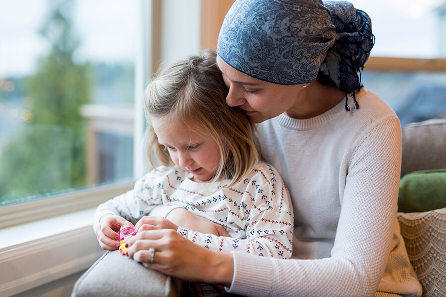 Mother wearing headscarf with child in lap