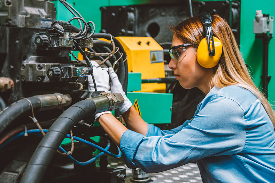 Woman repairing heavy-duty machine