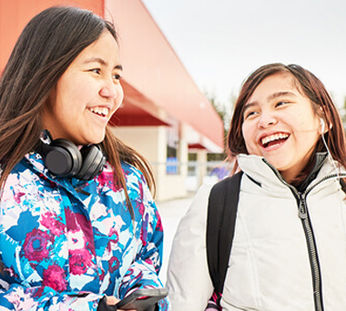 Two Indigenous teenagers laughing