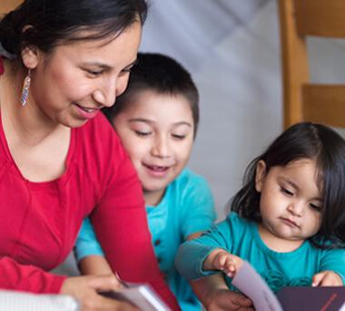 Indigenous mother teaching her two children