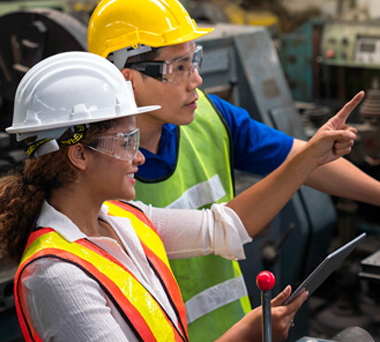 Two workers in safety gear in industrial setting
