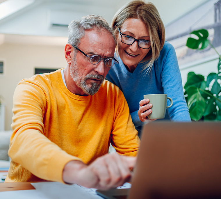 couple reading, couple on computer, people looking at inflation numbers, retired couple