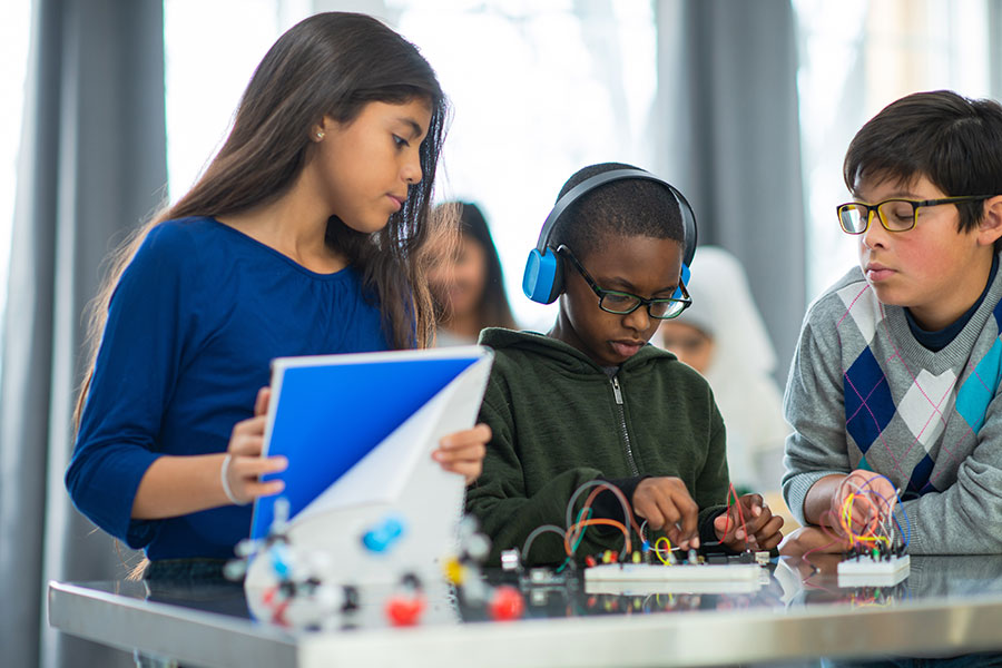 Children learning to build circuit boards