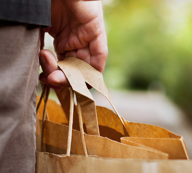 a man is holding a paper shopping bag