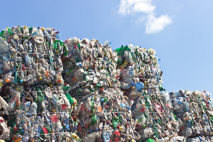 Stack of plastic bottles for recycling against blue sky