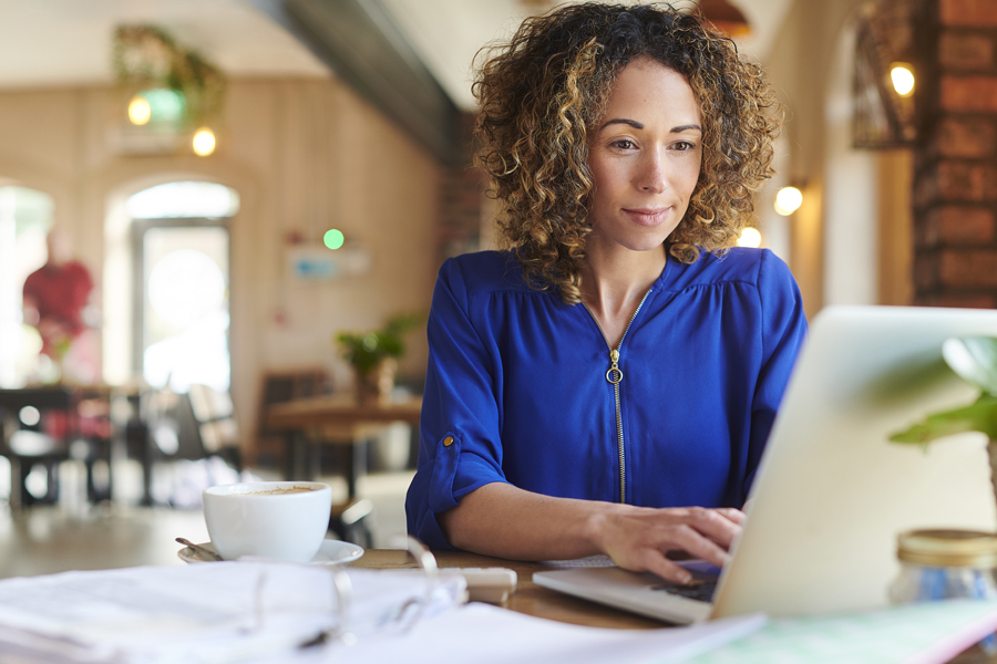 Woman working on laptop in a cafe