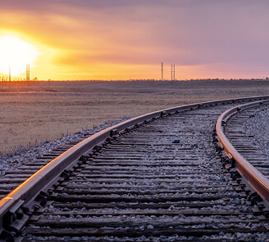Train tracks bearing right in an empty landscape