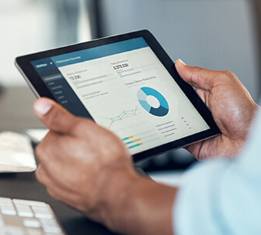 Hand holding tablet displaying data
