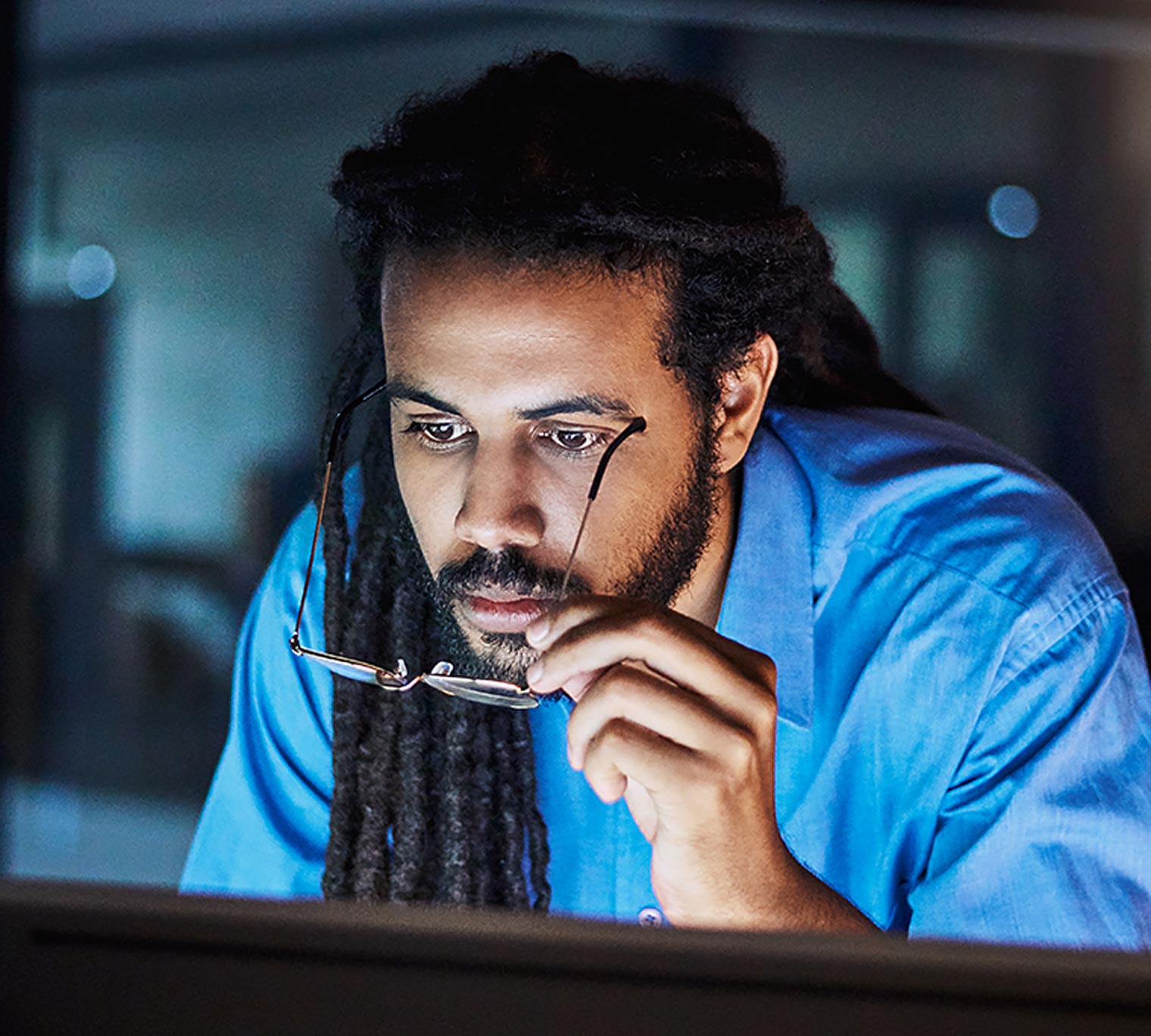 African-american man closely inspecting something on a computer screen