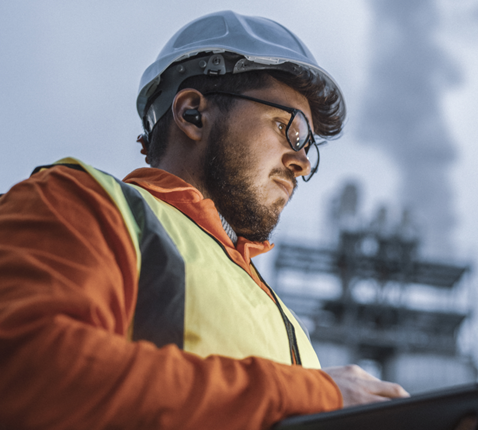 Engineer using laptop while working in oil and gas industry.