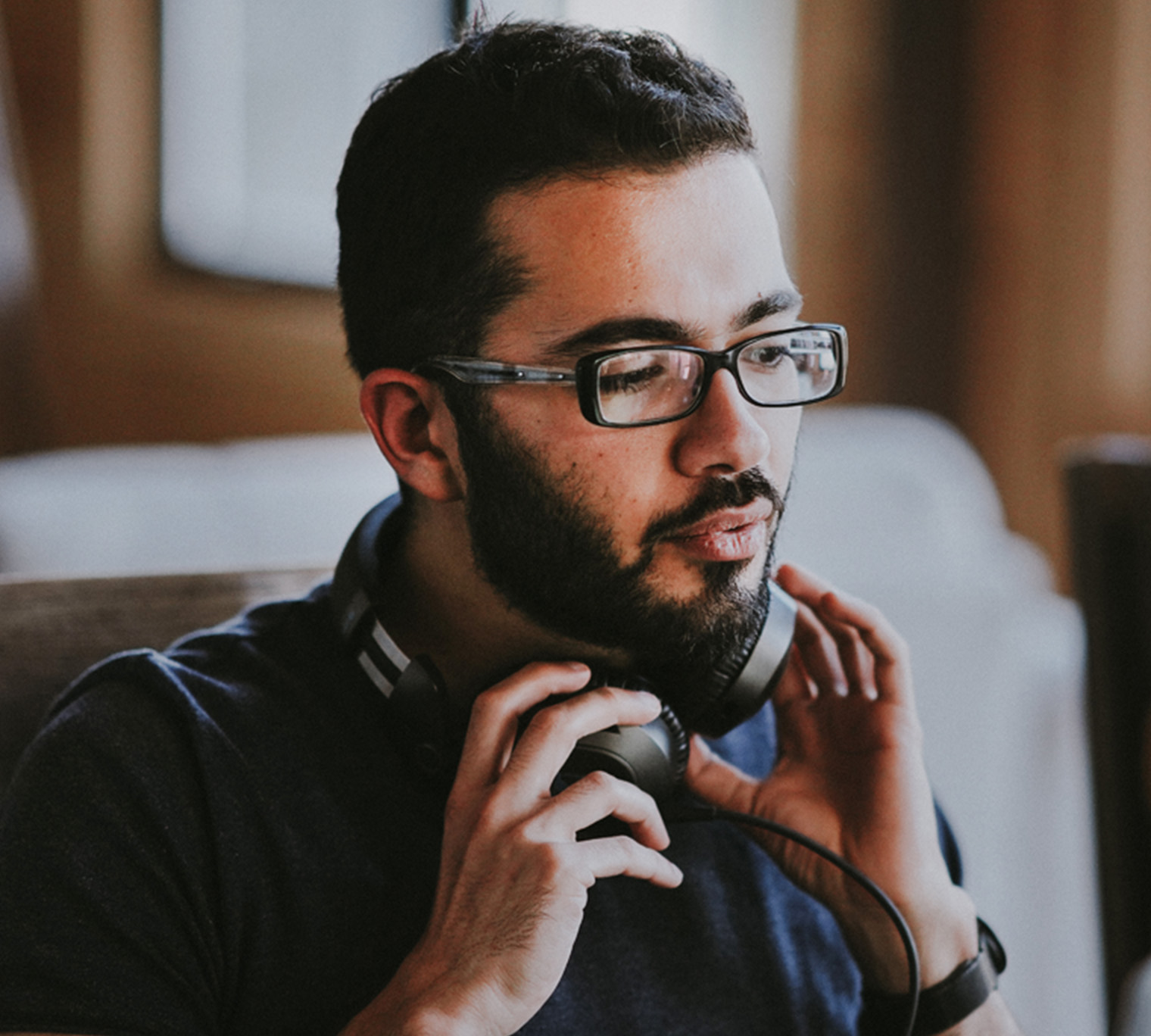 Man at computer putting on headphones.