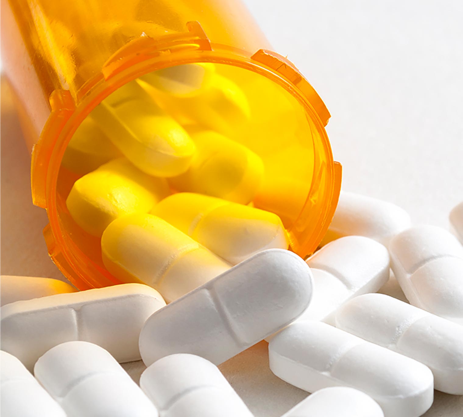 pill bottle tipped over spilling out white pills