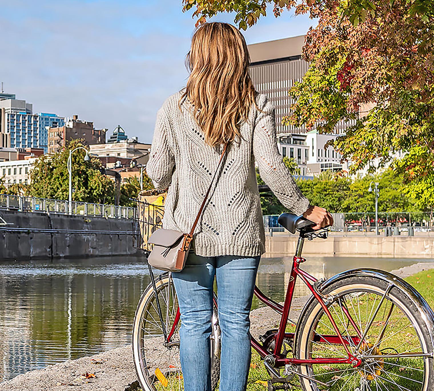 woman with bicycle looking out towards a city