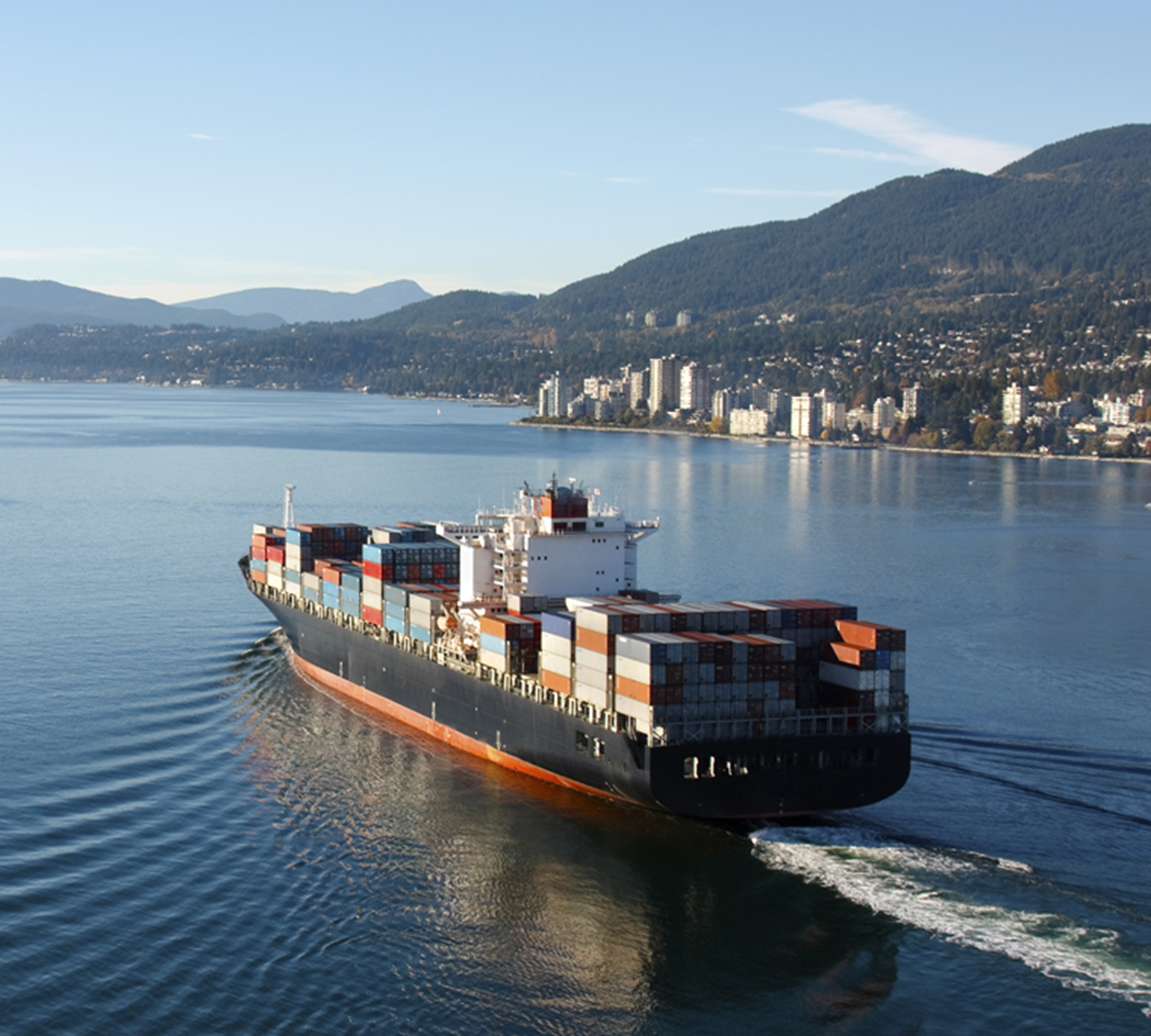Aerial photo of a loaded container ship leaving port.