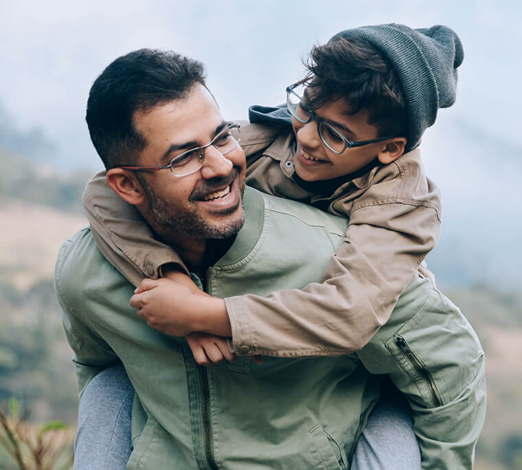An Indian man giving son a piggyback
