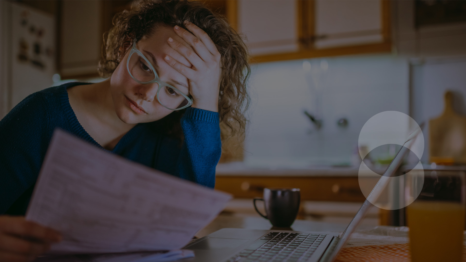 Person reviewing paperwork with hand on forehead looking very focused.