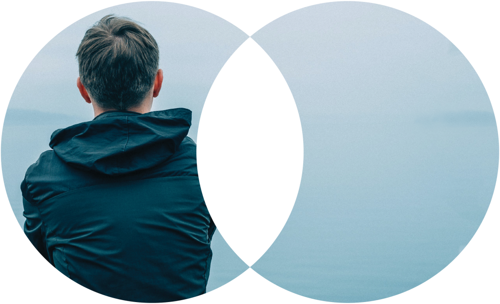 person staring out across a grey water