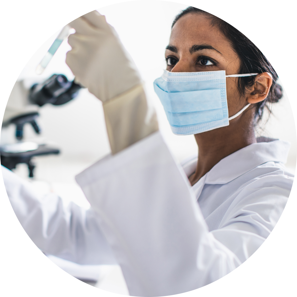 Lab technician hold up a test tube while wearing a mask