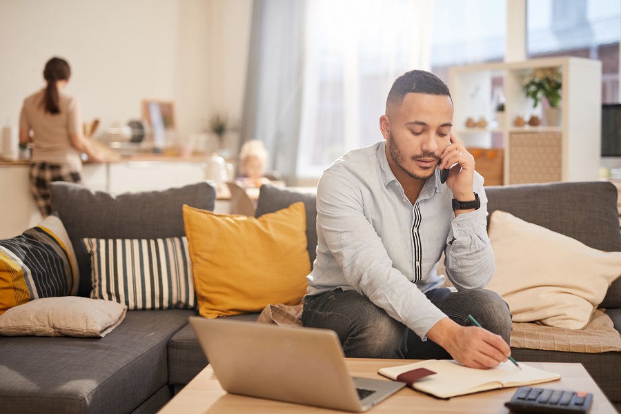 Man working from home; family in background