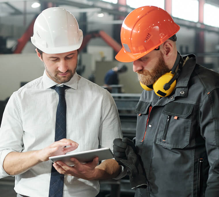 Two men conferring over a tablet device