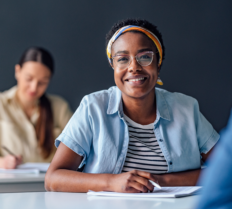 Smiling woman taking notes in class