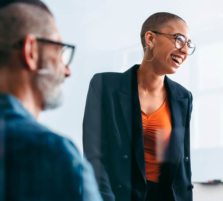 Standing woman laughing while presenting to colleagues