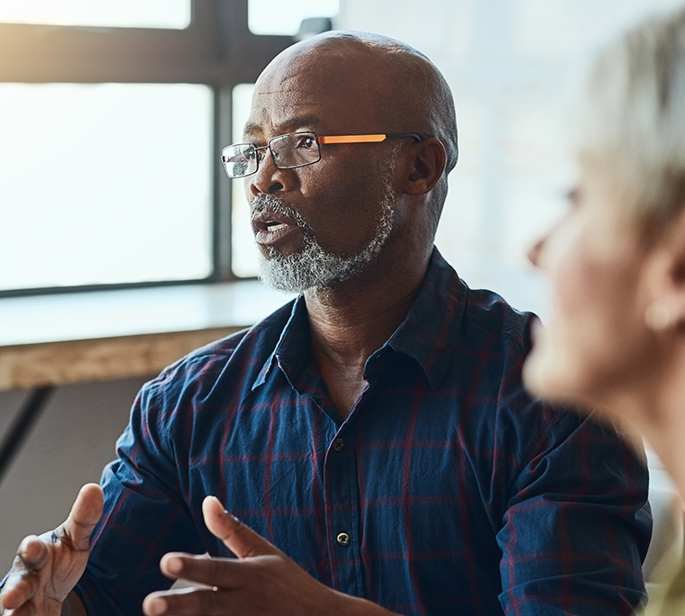 Man talking to colleagues in office setting
