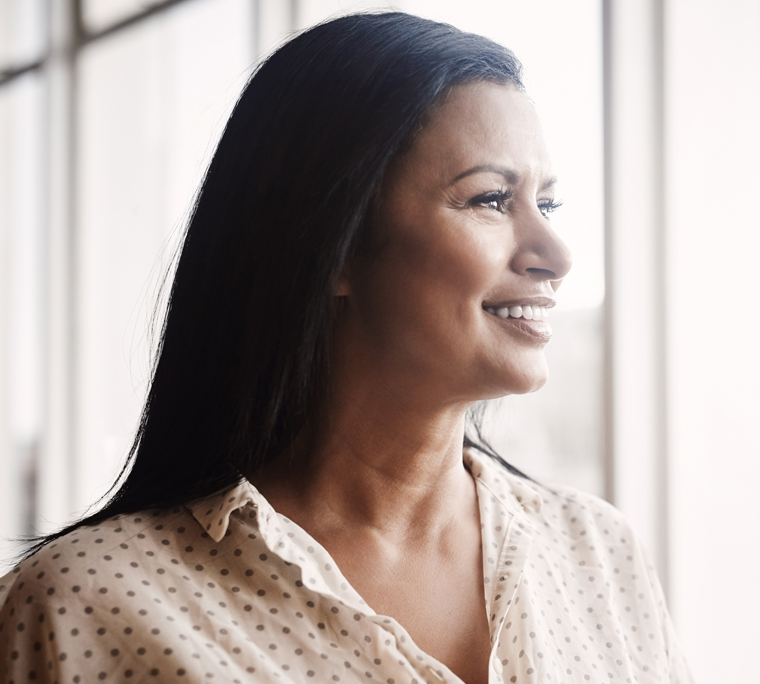 Mature businesswoman looking out window in an office