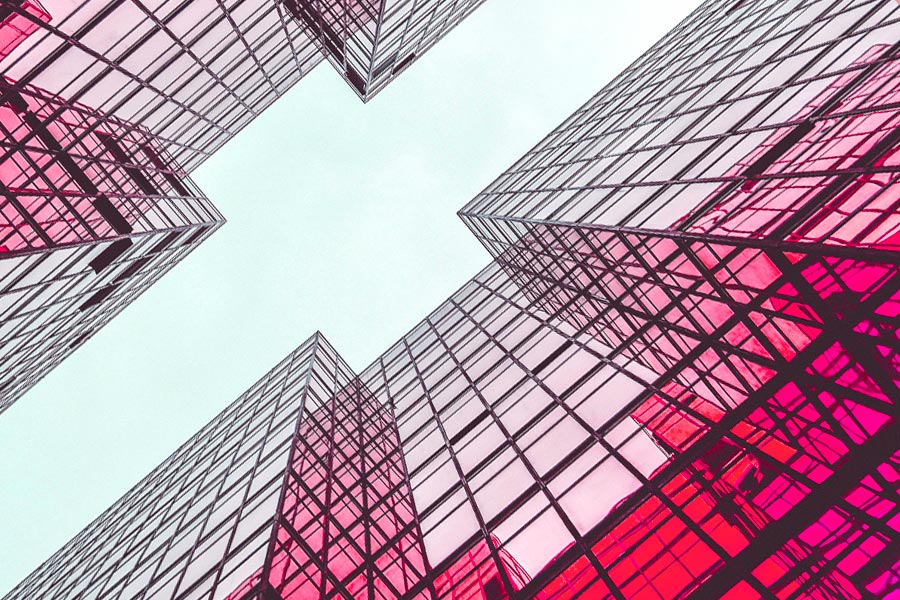 Looking up between glass office buildings