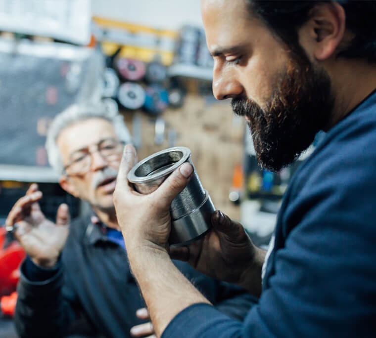 Man instructing apprentice in workshop