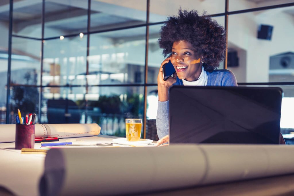 Woman on phone while working at drafting table