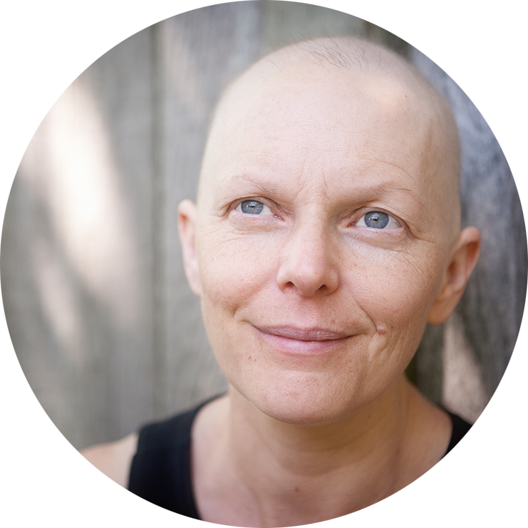 Balding woman fighting breast cancer outdoors looking off camera.