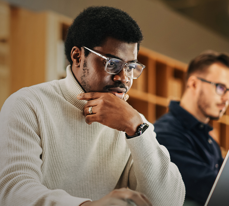 Man working on computer, looking pensive