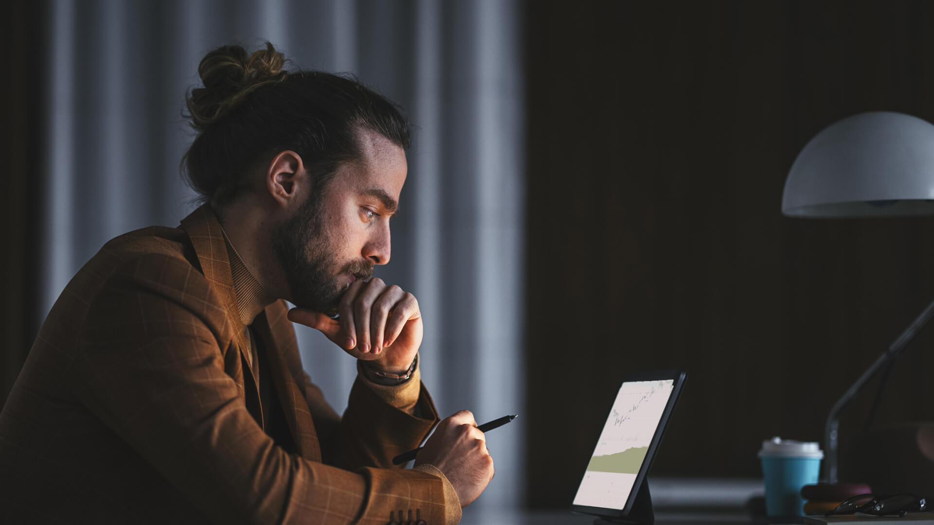 Man sitting at table reading on his laptop