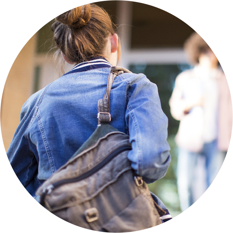 Close-up of student from behind, walking with backpack