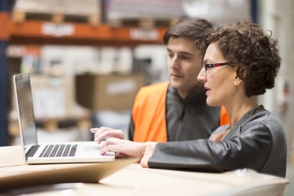 Woman teaching co-worker on the job