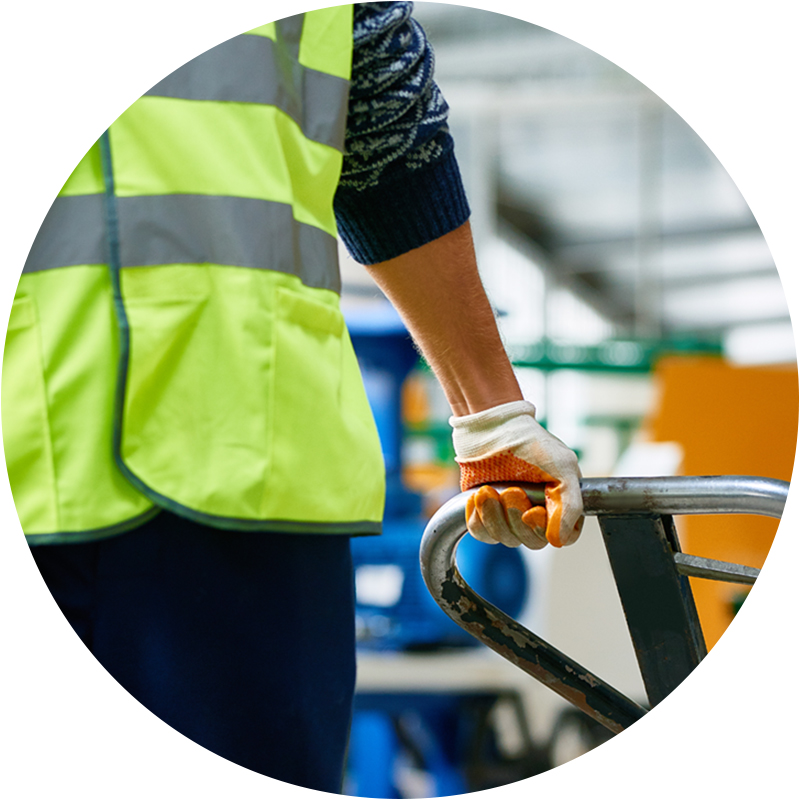 Factory worker holding handle of cart