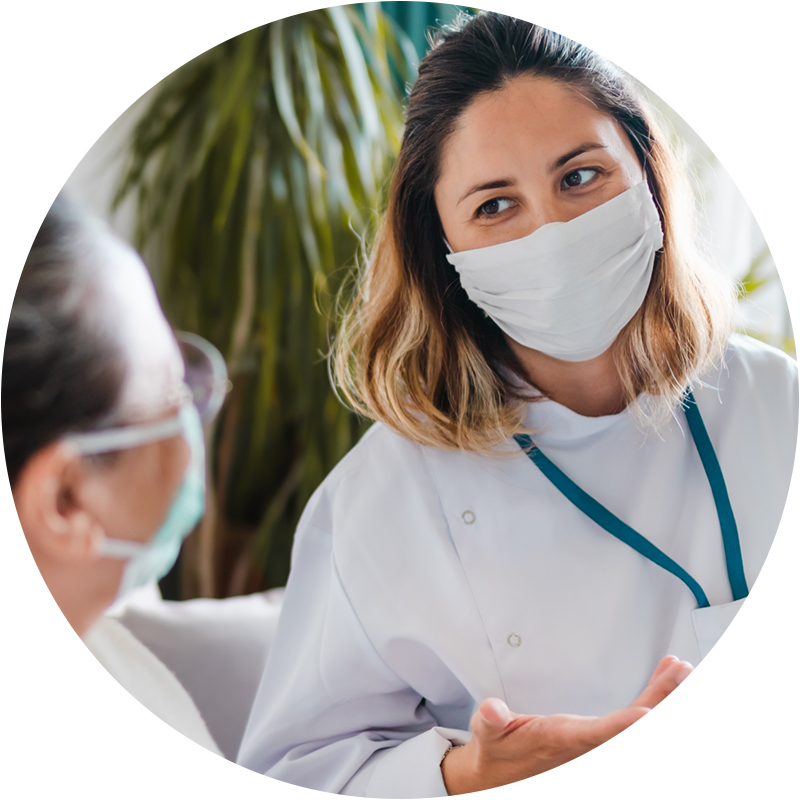 Nurse wearing mask talking to patient