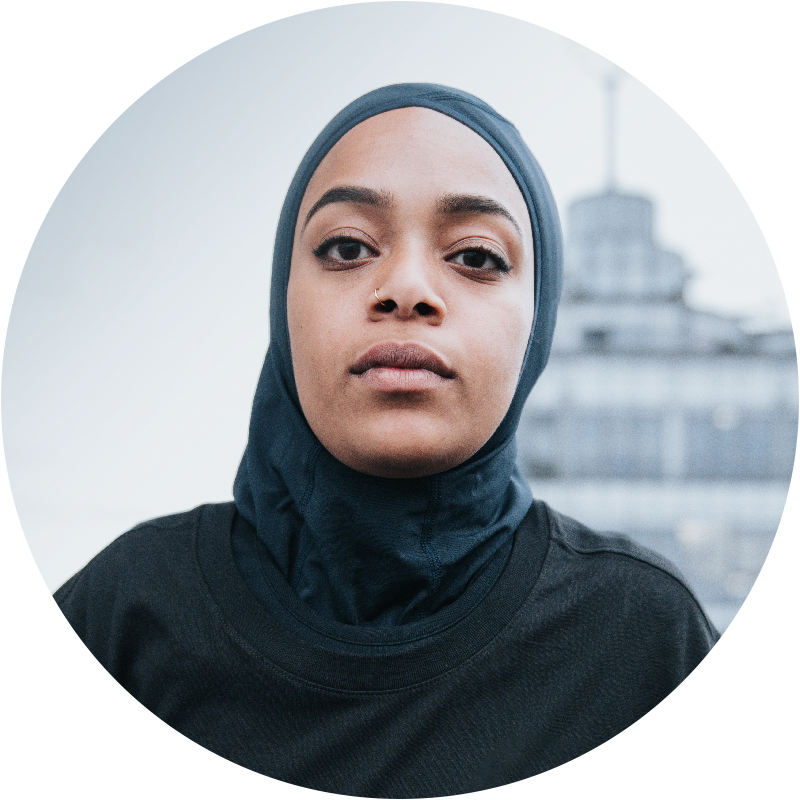 Serious woman looking at camera with city blurred in background