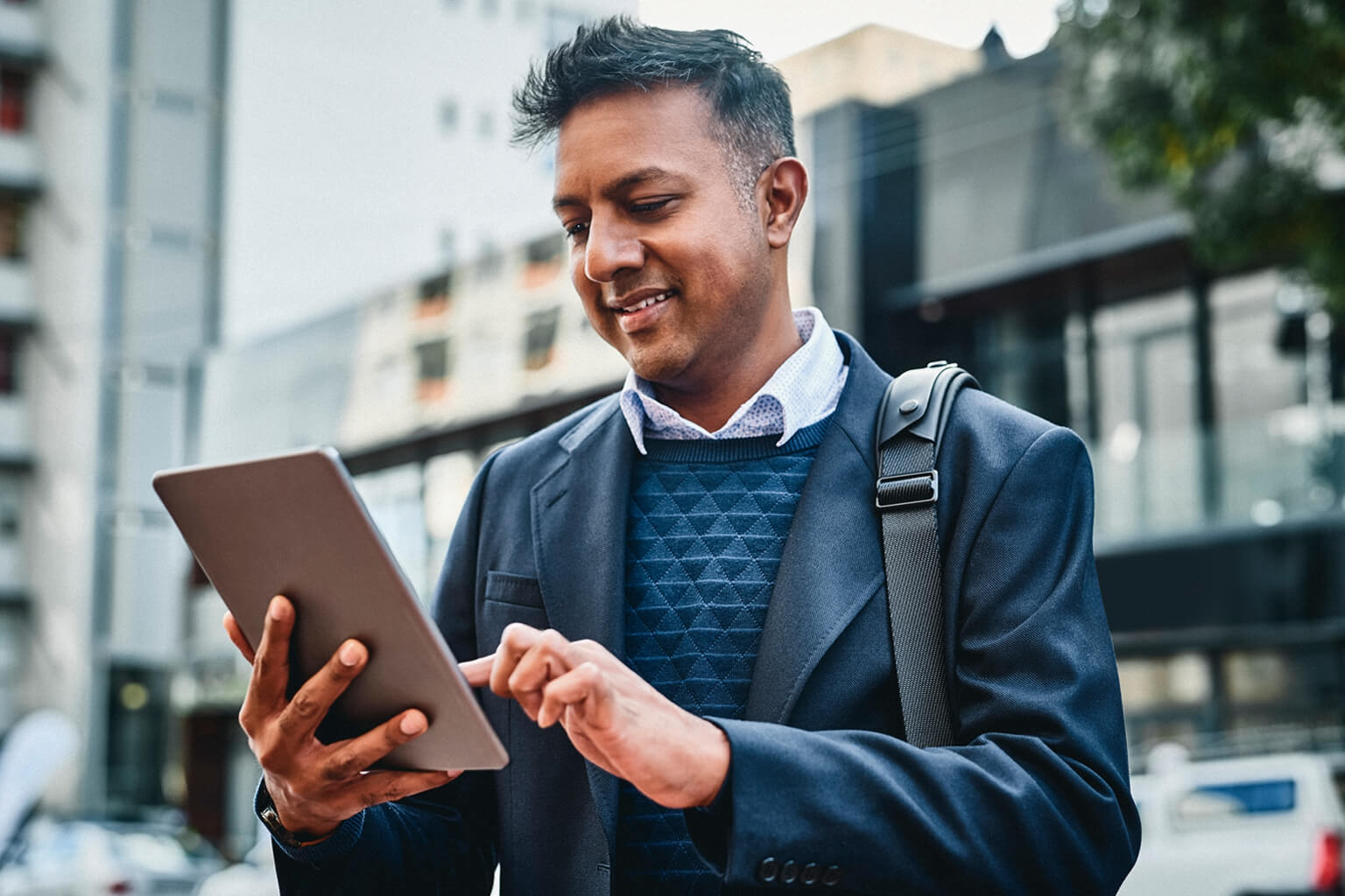 Man using tablet while standing on an urban street