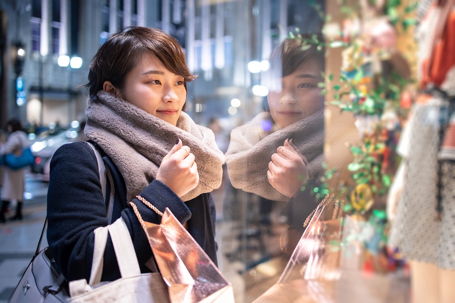 Woman in scarf window shopping
