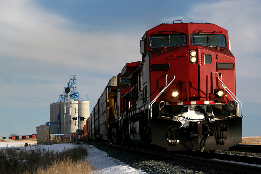 Train passing processing plant in a field
