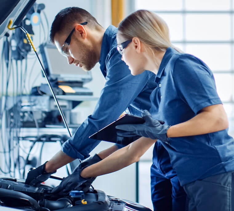Two people examining a car engine