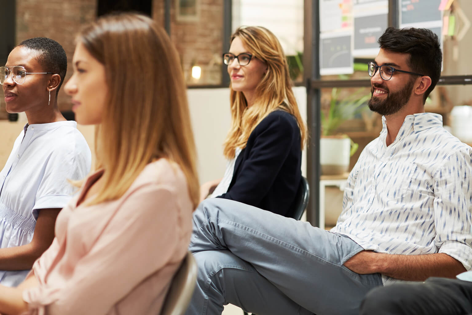 Group of diverse men and women listening to an unseen speaker